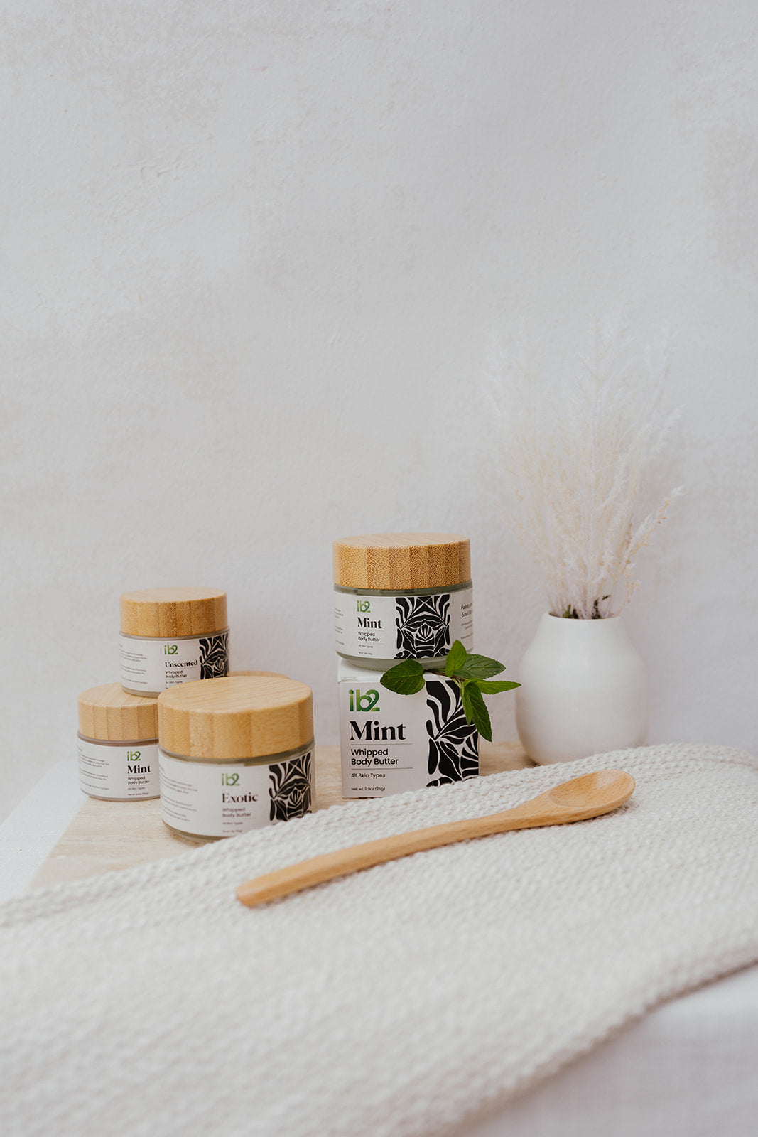 The full ib2 whipped body butter family, styled with pampas grass and fresh mint